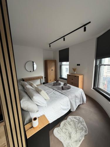 a bedroom with a large bed with white sheets and pillows at 70 Bath Street in Saint Helier Jersey
