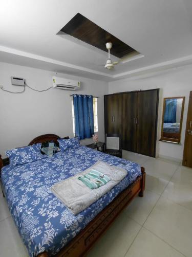 a bedroom with a bed with a blue comforter at Elite stay villa in Vākalapūdi