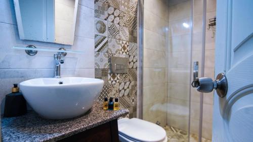 a bathroom with a white sink and a toilet at Bozcaada Aspava Otel in Bozcaada