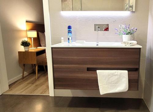 a bathroom with a sink and a vanity with a towel at Jardim das Oliveiras - Suítes com Vista in Ponte de Lima