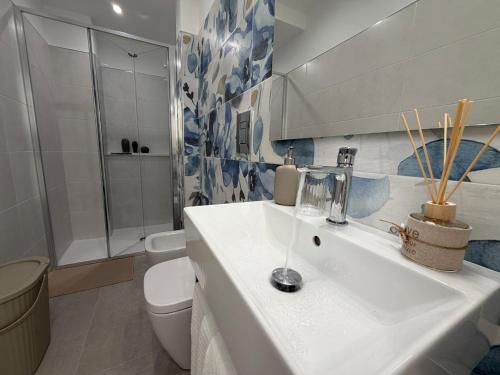 a bathroom with a white sink and a toilet at Donna Dina in Avola