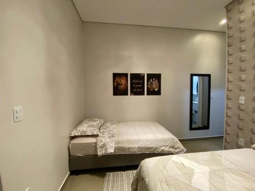 a bedroom with two beds and a mirror at Casa linda e nova, 01 suíte, 02 camas - até 03 pessoas in Chapecó