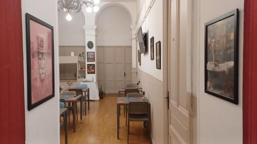 a dining room with tables and chairs and a hallway at Albergo Malibu in Sanremo