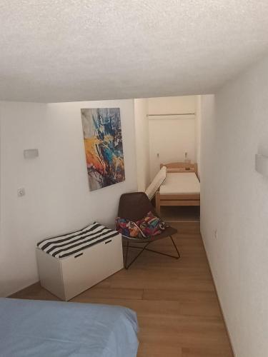 a bedroom with a bed and a chair in a room at River & Garden Apartment in Trebinje