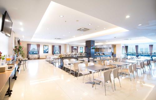 un restaurant avec des tables et des chaises ainsi qu'un bar dans l'établissement Hotel 88 - Mangga Besar VIII Jakarta By WH, à Jakarta