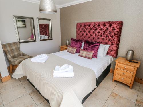 a bedroom with two beds with towels on them at Oak Tree Cottage - Gower in Swansea