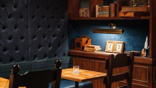 a dining room with a wooden table and two chairs at Ruby Stella Hotel London by IHG in London