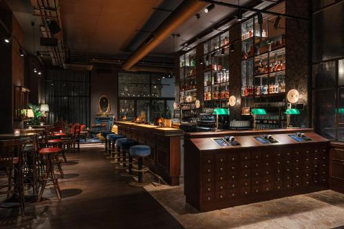 a bar with a lot of bar stools at Ruby Stella Hotel London by IHG in London