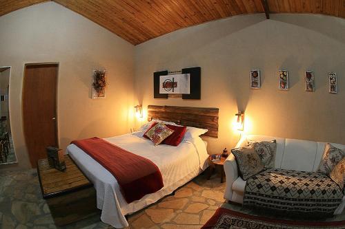 a bedroom with a bed and a chair at Cabana Refúgio da Mata in Juquitiba