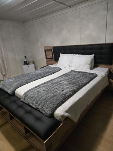 a bedroom with a large bed with a gray blanket at Zimmer perla in Chur