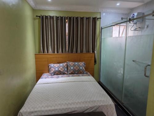 ein kleines Schlafzimmer mit Bett und Glasdusche in der Unterkunft Eliteclassy in Iju