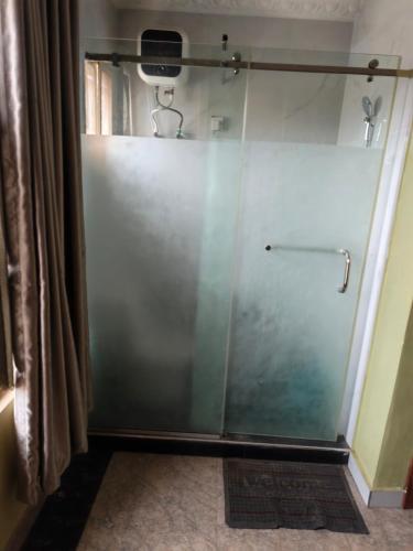 eine Dusche mit Glastür im Badezimmer in der Unterkunft Eliteclassy in Iju