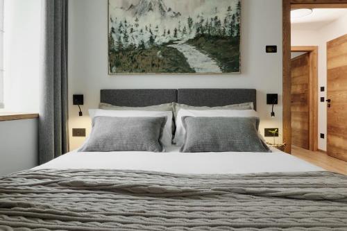 a bedroom with a large bed and a painting on the wall at Alp Tirol Home in Pellizzano