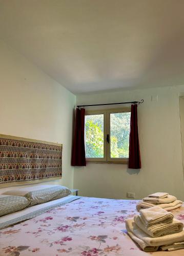 ein Schlafzimmer mit einem Bett mit roten Vorhängen und einem Fenster in der Unterkunft Parco Delle Valli in Sassari