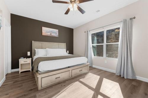 a bedroom with a bed and a ceiling fan at Spring Special Hot Tub King Beds No Steps No Dog Fee in Branson