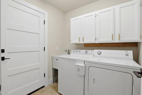 a kitchen with white cabinets and a washer and dryer at The Fairway To Heaven in Rathdrum