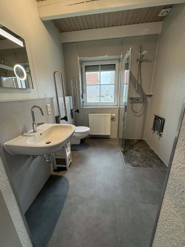 a bathroom with a sink and a toilet and a shower at SörenHuus Neßmersiel in Dornum
