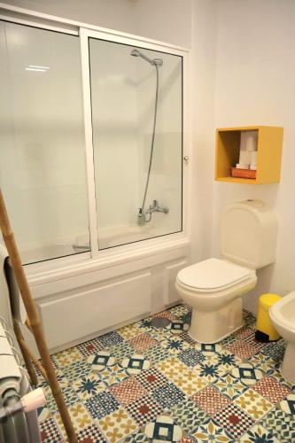 a bathroom with a toilet and a glass shower at Yellow House Aveiro Smart TV and garage in Aveiro