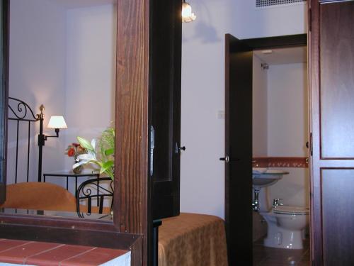 sypialnia z łóżkiem oraz łazienka z toaletą w obiekcie Casa de los Naranjos w Kordobie