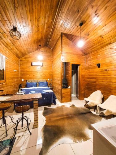 a bedroom with a bed and a wooden ceiling at Cabanas Sitio Amigos in Bento Gonçalves