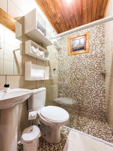 a bathroom with a toilet and a sink and a shower at Cabanas Sitio Amigos in Bento Gonçalves
