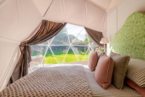 a bedroom with a canopy bed with a large window at 53 North in Bodham