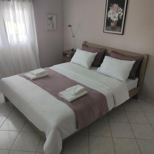 a bedroom with a large bed with two pillows at Smaro house in Filótas