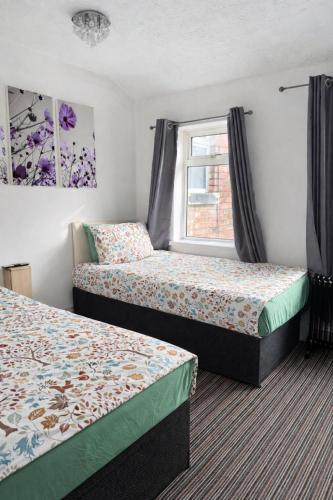 a hotel room with two beds and a window at Cadeby Lodge in Blackpool