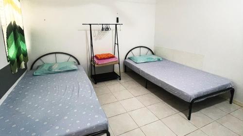 two beds sitting in a room with at Lin Homestay in Lahad Datu