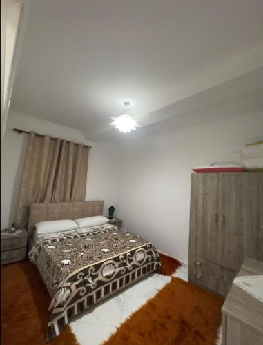 a bedroom with a bed and a light on the ceiling at Shtepi Pushimi in Mezhgoran