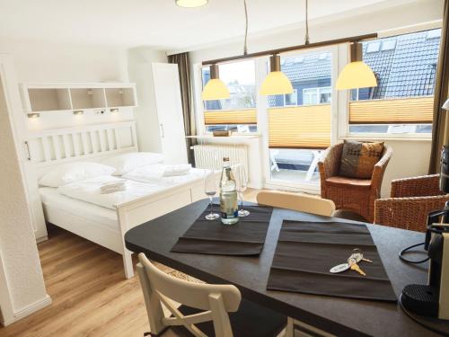 a room with a dining table and a living room at Strand Sand Sylt in Westerland