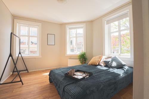 a bedroom with a bed and two windows at Urban Centre in Bergen