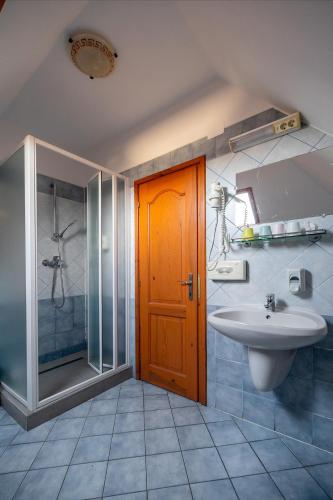 a bathroom with a sink and a shower and a toilet at Főnix Fogadó in Lenti