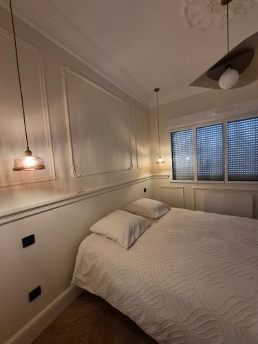 a bedroom with a bed and two windows at Appartement duplex Granville in Granville
