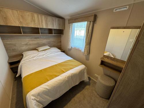 a small bedroom with a bed and a mirror at Sun & Sand, Near Padstow, Seven Bays, Sleeps 6 in Saint Merryn