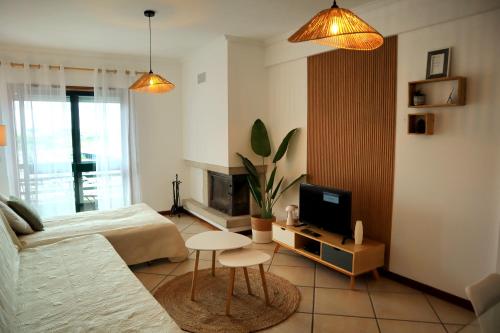a living room with a bed and a tv at Gare Do Sol Free Parking and Smart TV in Aveiro