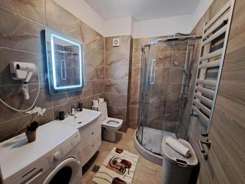 a bathroom with a shower and a sink and a toilet at Opium STUDIO ALEZZI in Mamaia Sat/Năvodari