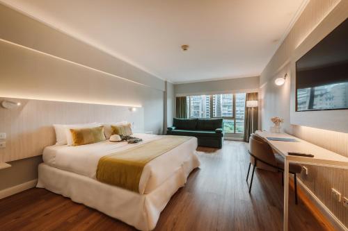 a hotel room with a large bed and a couch at Pestana Buenos Aires in Buenos Aires