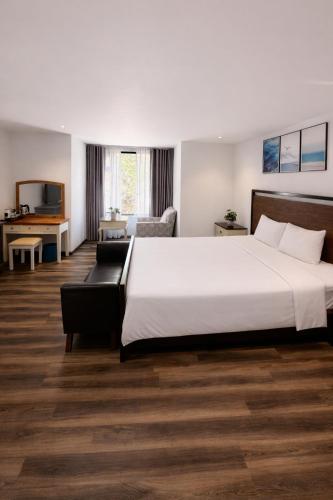 a hotel room with a large bed and a couch at Camly Chic Villa in Da Lat