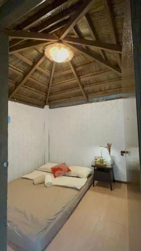 a bedroom with a bed and a table with a light at Coron Cozy Nature Hut in Coron