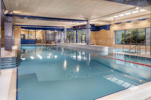 a large swimming pool with blue water in a building at Abbey Hotel Roscommon in Roscommon