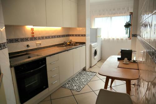 a kitchen with a sink and a table in it at Gare Do Sol Free Parking and Smart TV in Aveiro