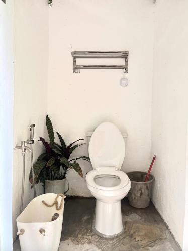 a bathroom with a toilet and plants in it at Coron Cozy Nature Hut in Coron
