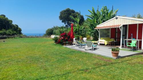 a house with a deck with chairs and a table at Cabana Papoila in Colares