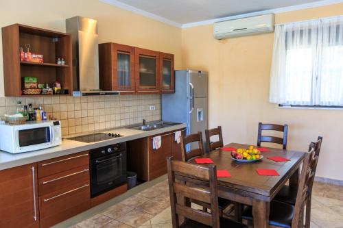 a kitchen with a table with a bowl of fruit on it at Villa Narcissus Montenegro KO Sveti Stefan in Sveti Stefan