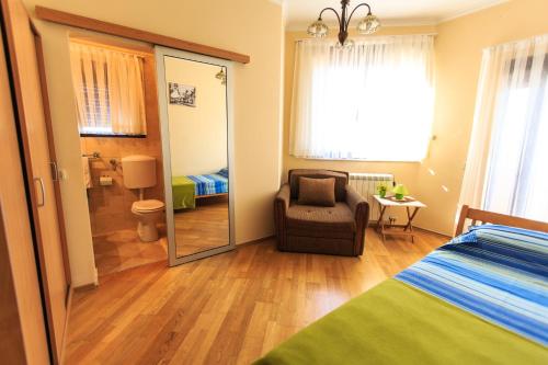 a bedroom with a bed and a chair and a mirror at Villa Narcissus Montenegro KO Sveti Stefan in Sveti Stefan