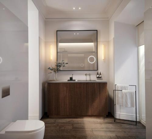 a bathroom with a sink and a toilet and a mirror at Hotel Rhin Garden in Santander