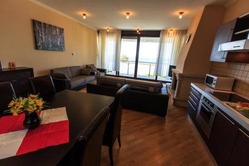 a living room with a dining room table and a kitchen at Villa Narcissus Montenegro KO Sveti Stefan in Sveti Stefan