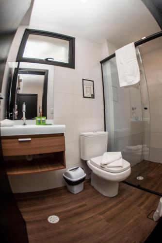 a bathroom with a toilet and a sink and a shower at Uny Hotéis Brás in São Paulo