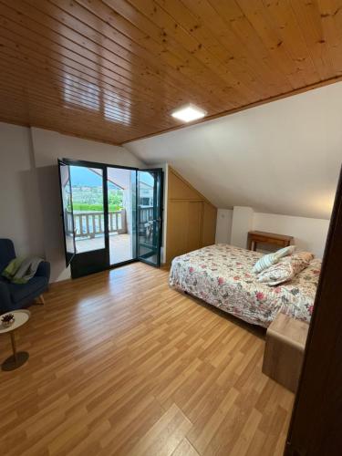 a bedroom with a bed and a wooden floor at A CASA DE SISAN in Ribadumia